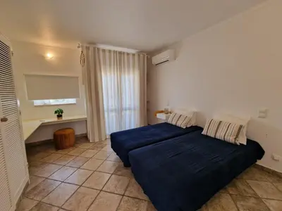 a bedroom with a blue bed and a window at Windmill Hill in Albufeira