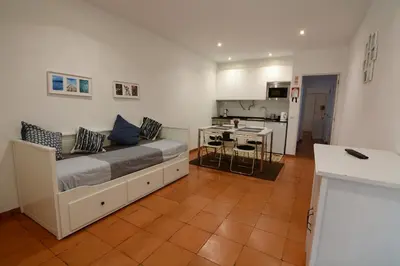 a living room with a bed and a kitchen at Charmosous Flat in Albufeira