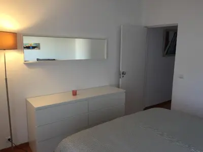 a bedroom with a bed and a dresser with a mirror at Charmosous Flat in Albufeira