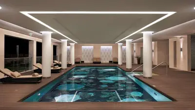 a large swimming pool in a hotel lobby at Conrad Algarve in Quinta do Lago