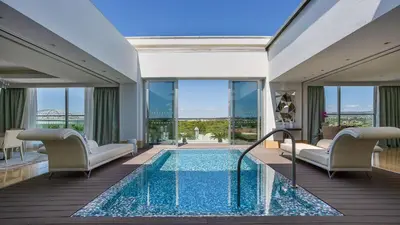 a swimming pool in a hotel room with windows at Conrad Algarve in Quinta do Lago