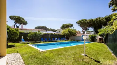 a swimming pool in the yard of a house at Villa Girassol in Vilamoura