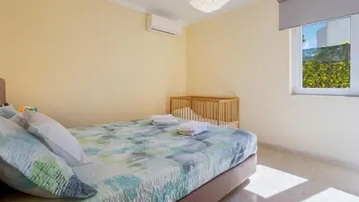 a bedroom with a bed and a window at Villa Girassol in Vilamoura
