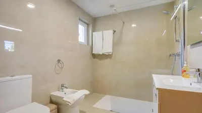 a bathroom with a toilet and a sink and a shower at Villa Girassol in Vilamoura
