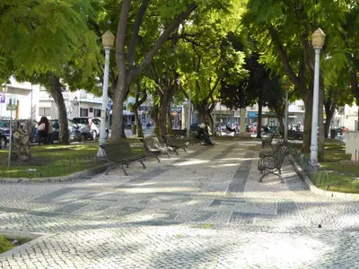 a group of benches in a park with trees at Downtown by Check-in Portugal in Faro