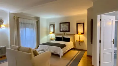 a bedroom with a bed and two chairs at Downtown by Check-in Portugal in Faro