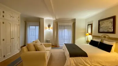 a bedroom with a bed and a couch and a chair at Downtown by Check-in Portugal in Faro