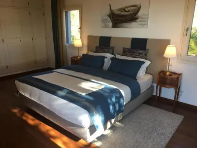 a bedroom with a large bed with blue pillows at Felicidade in Loulé