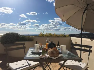 a table with a plate of food and an umbrella at Felicidade in Loulé