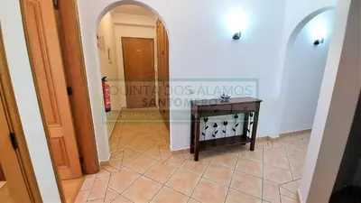 a hallway with an archway and a table on a tile floor at Apartamento AH in Guia