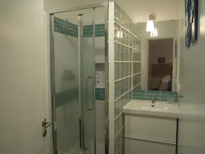 a bathroom with a glass shower and a sink at Estúdio tranquilo praia da Falésia in Albufeira
