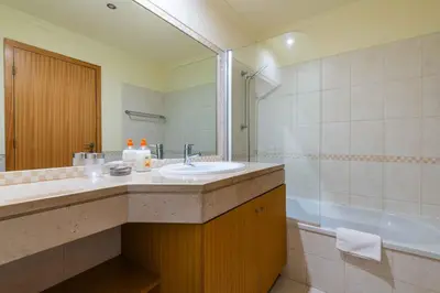 a bathroom with a sink and a shower and a tub at Vista das Ondas by Algarneto in Albufeira