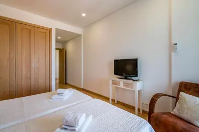 a hotel room with a bed and a television at Marina Vilamoura - Aquamar 401- Modern Apartment in Vilamoura