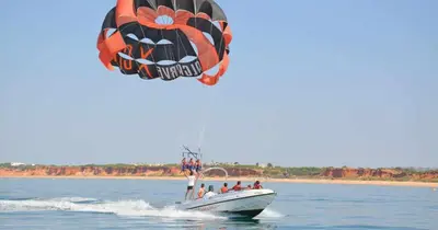 a group of people on a boat in the water with a parachute at Marina Vilamoura - Aquamar 401- Modern Apartment in Vilamoura