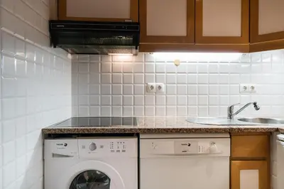 a kitchen with a washing machine and a sink at BmyGuest - Quinta do Lago Lounge Apartment in Almancil