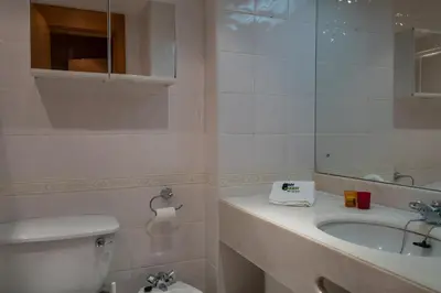 a bathroom with a sink and a toilet and a mirror at BmyGuest - Quinta do Lago Lounge Apartment in Almancil