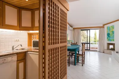 a kitchen with a table and a dining room at BmyGuest - Quinta do Lago Lounge Apartment in Almancil
