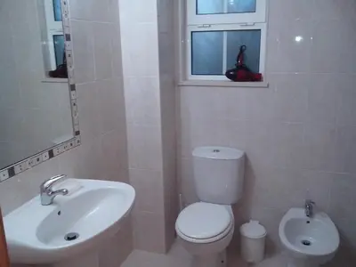 a bathroom with a white toilet and a sink at Albufeira 1 bedroom apartment 5 min from Falesia beach and close to center E in Albufeira