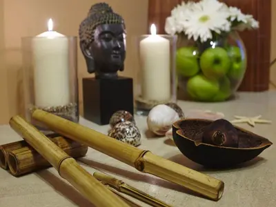 a table with candles and a statue of a head and a bowl and a candle at Four Seasons Vilamoura in Vilamoura