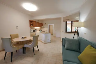 a living room with a table and a couch and a kitchen at Four Seasons Vilamoura in Vilamoura