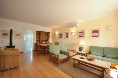 two chairs and an umbrella on a patio at Stylish and well-equipped, private pool, close to amenities, free AC Wifi in Quarteira