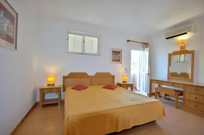a kitchen with white cabinets and a microwave at Stylish and well-equipped, private pool, close to amenities, free AC Wifi in Quarteira