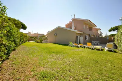 a yard with chairs and a house at Stylish and well-equipped, private pool, close to amenities, free AC Wifi in Quarteira