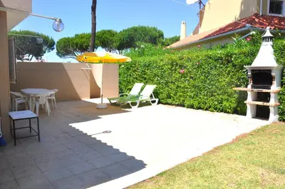 a swimming pool with a stone wall next to a house at Stylish and well-equipped, private pool, close to amenities, free AC Wifi in Quarteira