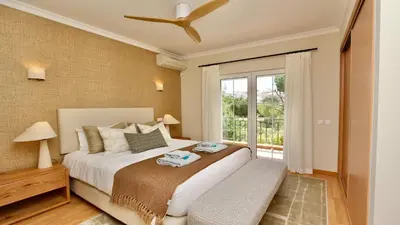 a bedroom with a large bed with blue curtains at Villa Amendoeira 4 - Clever Details in Vilamoura