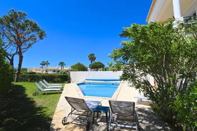 a living room with a white couch and a painting at Villa Amendoeira 4 - Clever Details in Vilamoura