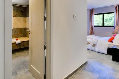 a door leading to a bedroom with a bed at Falesia Beach A in Roja- Pé