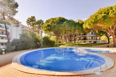 a large swimming pool with a fountain in a park at Falesia Beach A in Roja- Pé