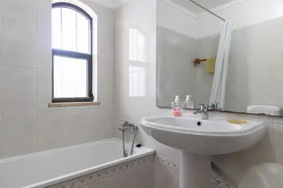 a white bathroom with a sink and a bath tub at Akisol Olhos de Agua Pine II in Albufeira