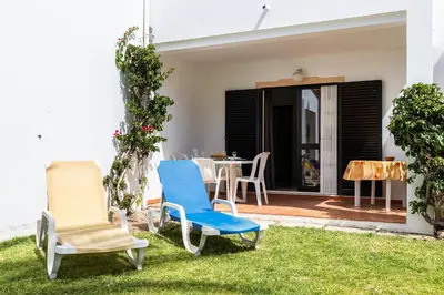 a pair of chairs and a table in a yard at Akisol Olhos de Agua Pine II in Albufeira