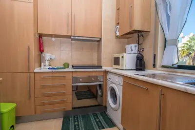a kitchen with wooden cabinets and a washer and dryer at Akisol Albufeira Guia II in Guia