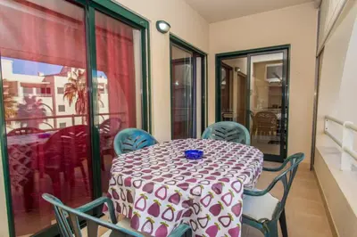 a table and chairs in a room with a balcony at Akisol Albufeira Guia II in Guia
