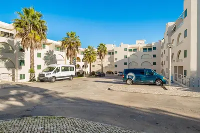 two cars parked in a parking lot in front of a building at Akisol Albufeira Guia II in Guia