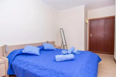 a bedroom with a blue bed with blue pillows at Akisol Albufeira Guia II in Guia