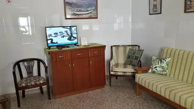 a waiting room with a tv and two chairs at Vivenda João Damas in Albufeira