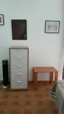 a bedroom with a dresser and a tv and a table at Vivenda João Damas in Albufeira