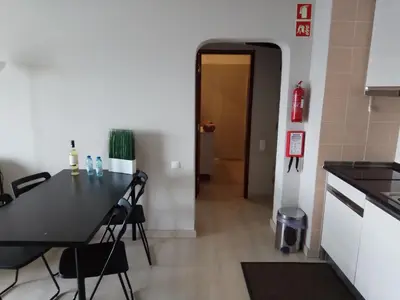 a kitchen with a table and chairs in a room at Apartamento de Praia - Albufeira in Albufeira