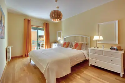 a bedroom with a white bed and a window at Marina Bay Residence in Albufeira