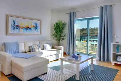 a living room with a white couch and a table at Marina Bay Residence in Albufeira