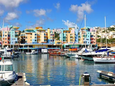 a group of boats docked in a marina with buildings at Marina Bay Residence in Albufeira
