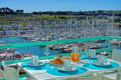 a table with food on a balcony with a marina at Marina Bay Residence in Albufeira