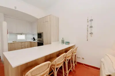 a kitchen with a white counter top and chairs at Villa Molgard 61 - Clever Details in Vilamoura