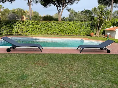 two benches sitting next to a swimming pool at Algarvila in Vilamoura