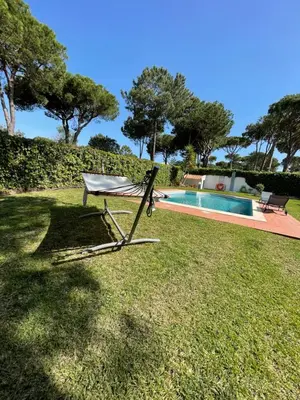 a chair sitting in the grass next to a swimming pool at Algarvila in Vilamoura