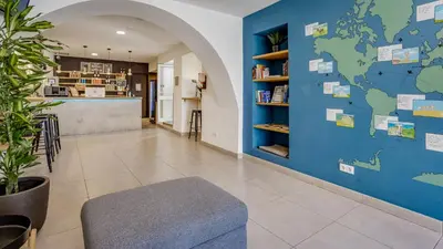 a lobby with a blue wall with a map of the world at Hostellicious in Faro