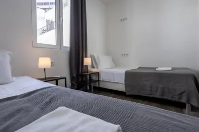 a hotel room with two beds and a window at Hostellicious in Faro